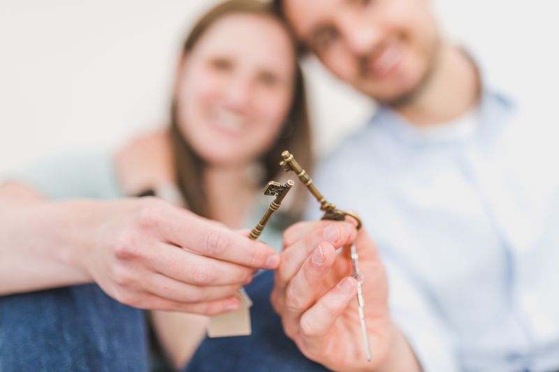 Couple souriant tenant les clés de son nouveau logement